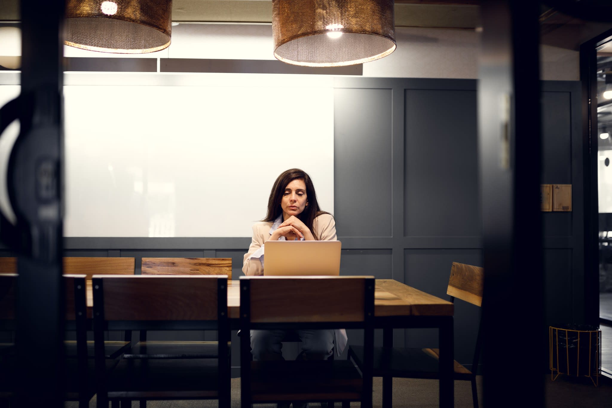 Modern small business owner researching crypto banking options on a laptop in a bright, contemporary office in 2025